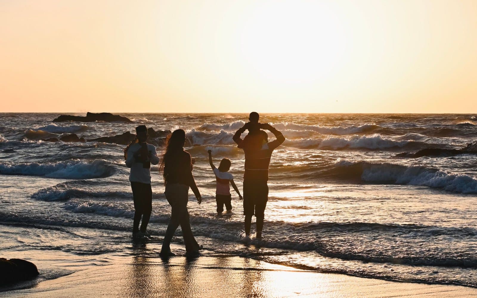A family in silhouette at the shoreline at sunset, Fuerteventura