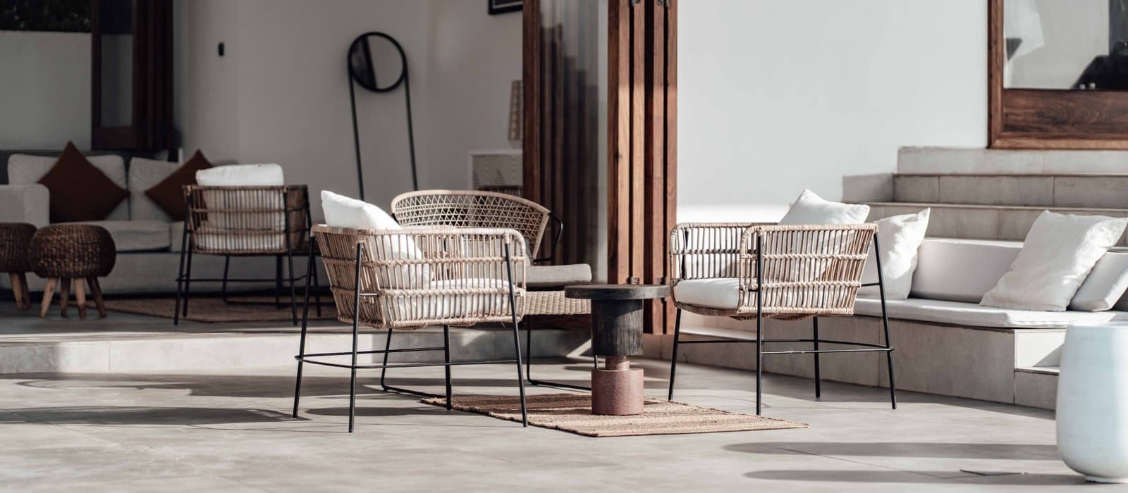 A poolside terrace with chairs in the shade